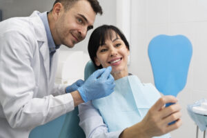 pessoa no dentista feliz com o sorriso, representando a importância do seguro odontológico