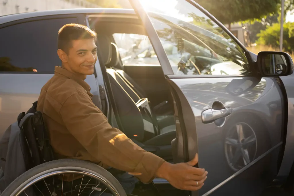 Homem em cadeira de rodas acessando carro adaptado, promovendo inclusão e acessibilidade para seguro carro PCD.